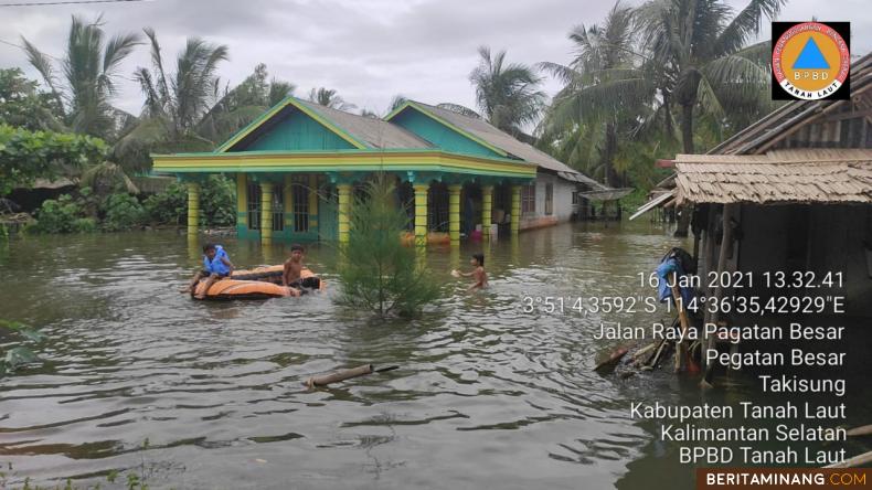 Tim penyelamat sedang mendekati rumah warga yang terendam banjir di Kalsel. Foto: Humas BNPB