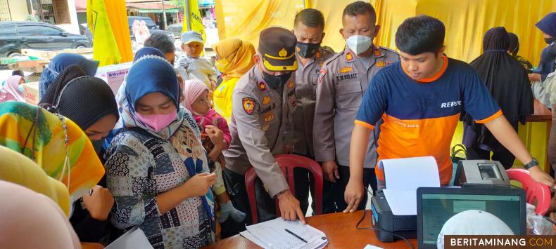 Wakapolres Sawahlunto Joni Darmawan membantu warga mendaftarkan diri bersedia divaksin saat Gebyar Vaksinasi Partai Golkar siang tadi. Foto: Iyos