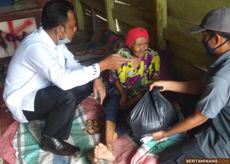 Wali Nagari Pasir Talang Nofi Wandra tengah menyerahkan sembako pada nenek Nurcaya Namo, Senin (18/5). Foto Afrizal. A