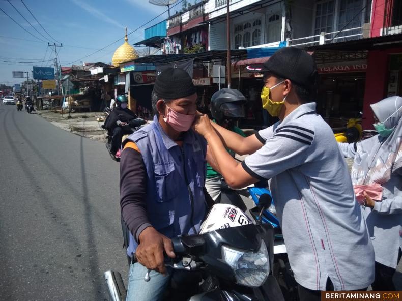 Wali Nagari Lingkuang Aua Fahrezi.S.IP.MA ketika memasangkan masker kepada warga.