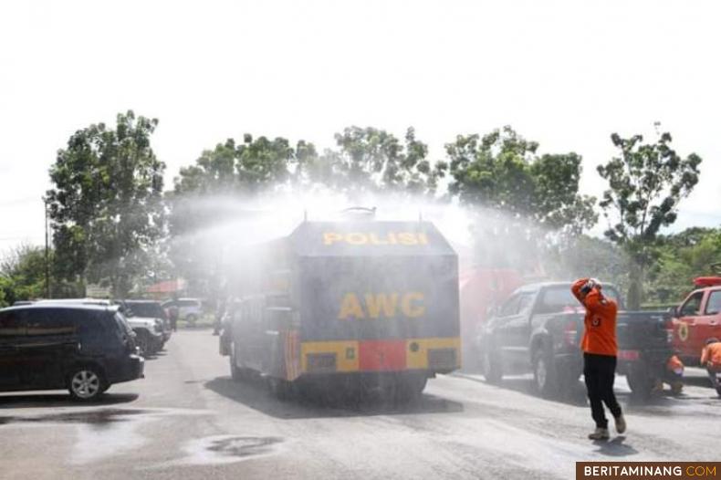 Mobil water canon milik Polres Pasbar sedang menyemprot disinfektan ke fasum.
