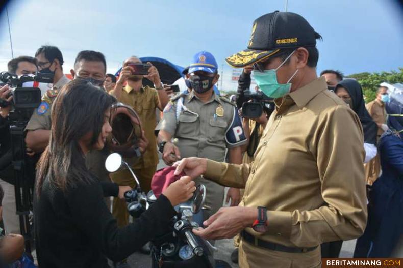 Gubernur Sumatera Barat Irwan Prayitno lakukan sosialisasi aturan Perda itu kepada masyarakat dengan membagikan masker dan hand sanitizer secara gratis di kawasan Danau Cimpago Padang. Foto Humas Sumbar
