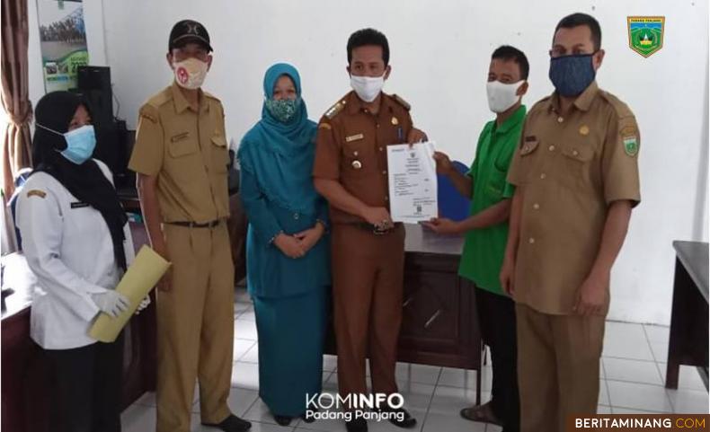 Petugas sedang memperlihatkan surat kematiaan salah satu warga di Kelurahan TPL Padang Panjang
