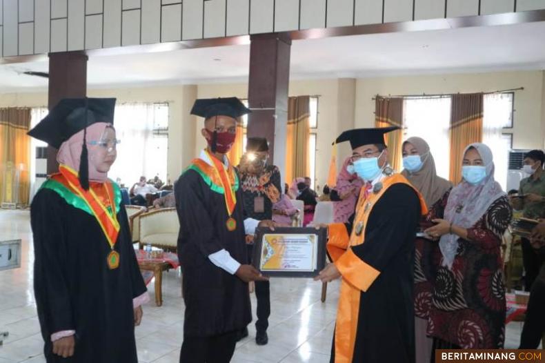Direktur Politeknik Negeri Padang Surfa Yondri, menyerahkan plakat tanda lulus pada salah seorang lulus PDD PNP, Akademi Komunitas Kab. Solsel di aula Sarantau Sasurambi,  Rabu (11/11/2020). Foto: Afrizal. A