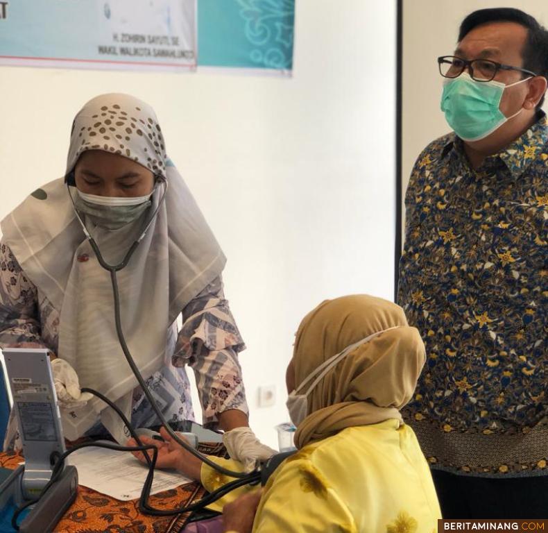 Salah seorang petugas kesehatan di Sawahlunto tengah melakukan pemeriksaan kesehatan kepada lansia dalam upaya menekan angka penularan melalui vaksinasi. Foto: Satgaskes