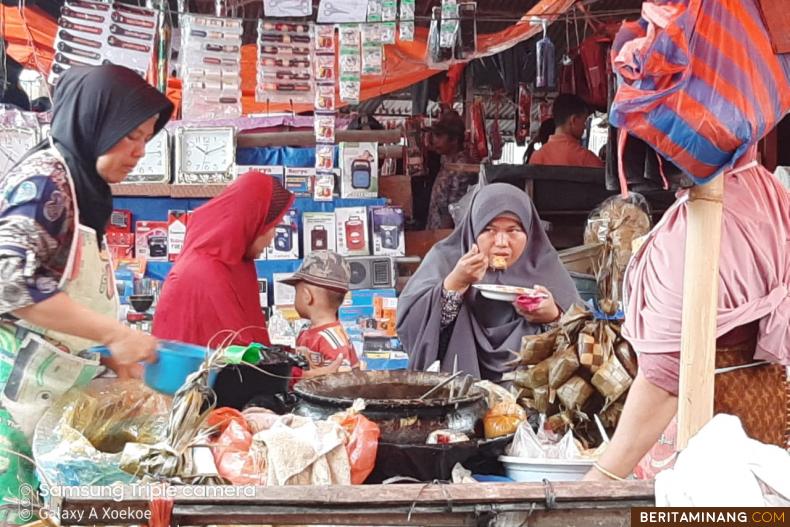 Seorang pembeli sedang santap Katupek Pitalah di Pasar Sumani, Solok. suhanews.co.id
