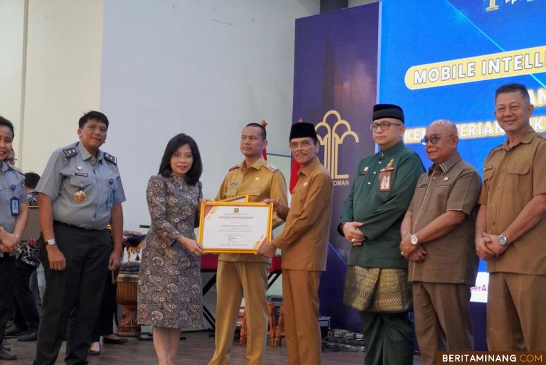 Bupati Safaruddin menerima penghargaan Program Kekayaan Intelektual di tahun 2023 yang diserahkan oleh Direktur Jenderal Kekayaan Intelektual Min Usihen di Youth Centre Bagindo Aziz Chan Padang, Selasa (19/09/2023.Foto : Dok Kominfo Liko