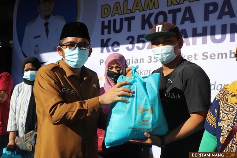 Wako Padang Hendri Septa saat menyerahkan bantuan kepada penerima bantuan. Foto: Humas Kota Padang