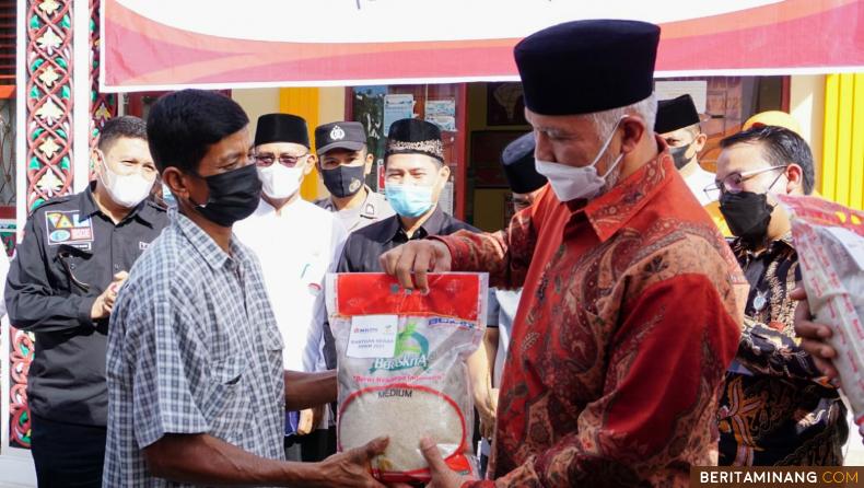 Gubernur Sumatera Barat Mahyeldi saat menyerahkan bantuan beras kepada salah satu warga Lubuk Basung di Kantor Pos Walinagari Kampung Pinang Lubuk Basung, Kabupaten Agam, Jumat (30/7/2021).