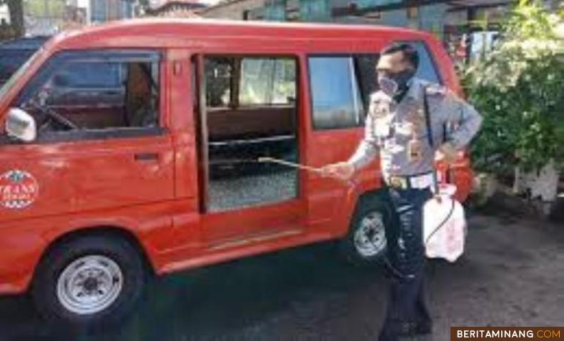 Petugas kepolisian semprotkan disinfektan pada kendaraan umum di Kabupaten Agam.