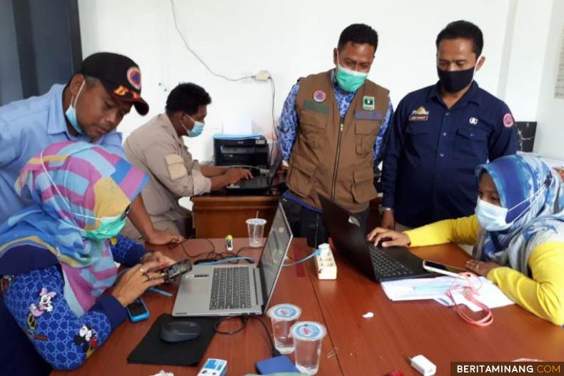Anggota Posko COVID-19 Sawahlunto tengah sibuk dengan laporan data perkembangan pandemi corona virus, mereka bersemangat ditemani Sekretaris Gugus Tugas Adri Yusman. Foto: Iyos