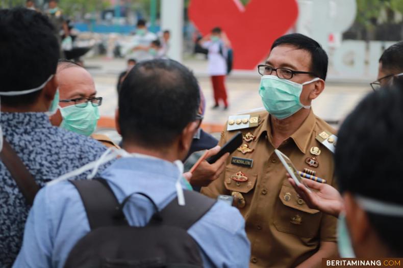 Bupati Hendrajoni diwawancarai wartawan usai bagikan masker pada warga. Foto Humas Pessel