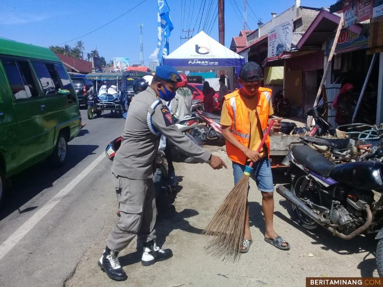 Salah seorang pelanggar ketika menjalani sanksi berupa kerja sosial di Pasar Tarusan Kecamatan Koto XI Tarusan, Selasa (15/6).