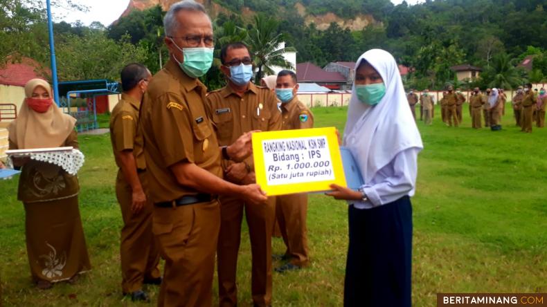 Pjs Bupati Pesisir Selatan, Mardi menyerahkan piagam penghargaan kepada tiga orang pelajar SMP dan SD yang meraih prestasi dalam ajang Kompetensi Sains Nasional (KSN) tingkat Provinsi Sumatera Barat dan nasional tahun 2020 ketika apel gabungan di GOR H.Ilyas Yakub Painan, Senin (27/10).