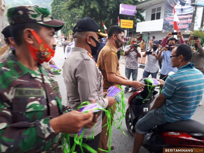 Wako Deri Asta didampingi Kapolres Sawahlunto Junaidi Nur dan dan Perwira Penghubung Kodim 0310 tengah memberikan masker kepada warga yang lewat untuk dikenakan seketika. Foto: Iyos