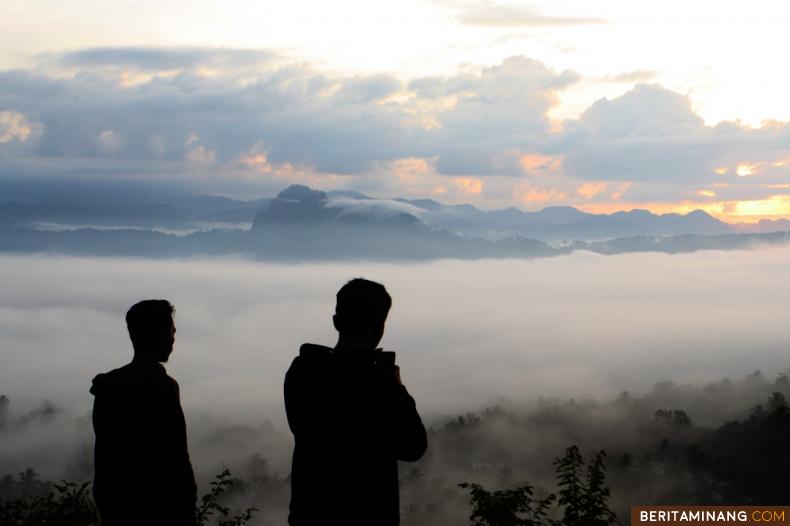 MENIKMATI KABUT - Warga menikmatai pemandangan kabut dingin yang menyelimuti wilayah Batusangkar dari atas Bukit Siduali, Tanah Datar, Sumbar, Jumat (29/05/2020). Foto Adi Prima