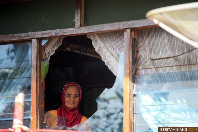 				Warga berada di dalam rumahnya yang rusak akibat bentrok di Jorong Suduik, Nagari Sumpu, Kabupaten Tanah Datar, Sumatera Barat, Selasa (13/10/2020). Bentrok terkait tapal batas Nagari Sumpu dan Malalo ini mengakibatkan kerugian belasan motor terbakar dan beberapa rumah di daerah itu rusak. (Beritaminang/AP)						